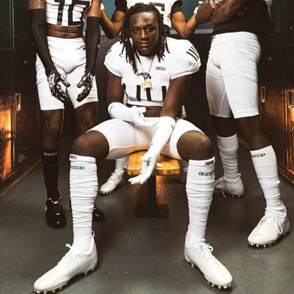 Football players wearing the Battle Adult White Long Football Socks.